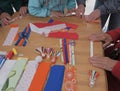 Hands working on bright fabric pieces during Mansi textile doll workshop Royalty Free Stock Photo