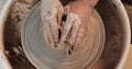 Hands working on pottery wheel with professional tools, shaping a relief on a clay plate. Top view. Potter at work Royalty Free Stock Photo