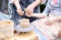 Hands working on throwing wheel, master class of studio pottery