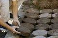 Hands of workman make it fit and to place stone pavers in a row. Construction site of pavement octagon bricks road. Installation