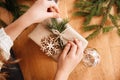 Hands wrapping present boubles christmas tree branches bright