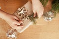 Hands wrapping present boubles christmas tree branches