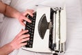 Hands writer bed white bedclothes working on new book. Writer author used to old fashioned machine instead of digital