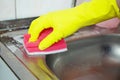 Hands in yellow gloves clean sink with sponge and a special cleaning agent, detergent spray. Hygiene in the kitchen, cleaning the Royalty Free Stock Photo