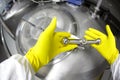 Hands in yellow gloves closing industrial process tank Royalty Free Stock Photo