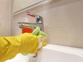 Hands in yellow gloves wash maid sink clean sanitary in the ceramic bathroom wash