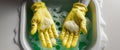 Hands in yellow gloves washing with soap and green suds Royalty Free Stock Photo
