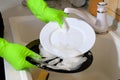 Hands in yellow protective rubber gloves washing dishes in the kitchen Royalty Free Stock Photo