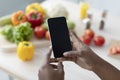 Hands of young african american woman hold smartphone with blank screen making photo on table Royalty Free Stock Photo