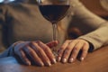 Hands of a young beautiful woman holding a glass of wine indoors of a stylish wine restaurant Royalty Free Stock Photo