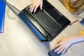 Hands of a young boy typing on a laptop keyboard over a rustic wooden table Royalty Free Stock Photo