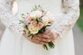 The hands of a young bride are holding a beautiful delicate wedding bouquet. Bride`s hand with a wedding ring on her finger. Brid Royalty Free Stock Photo