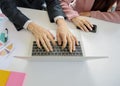 Hands of young business man work on laptop with hands of young business women grabs mobile phone with document and pen on white wo Royalty Free Stock Photo