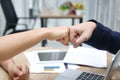 Hands of young business people giving fist bump together to greeting complete dealing in office. Success and teamwork concept Royalty Free Stock Photo