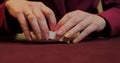 Hands of a young caucasian man playing poker in a casino. Close-up of hands playing poker with chips on red table. Royalty Free Stock Photo