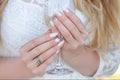 Hands of young caucasian woman holding glass of champagne during party. Bride wearing white dress . Beautiful tender wedding manic Royalty Free Stock Photo