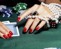 Hands of young caucasian woman with red manicure at casino table Royalty Free Stock Photo