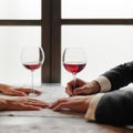 The hands of a young couple dating in a restaurant, there are two glasses of red wine on the table. Valentine day and togetherness Royalty Free Stock Photo