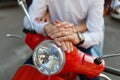 Hands of a young couple on the wheel of a scooter. Young and carefree. Beautiful young couple and sitting on a classic scooter tog Royalty Free Stock Photo