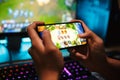 Hands of young gamer boy playing video games on smartphone and c