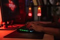 Hands of young gamer man playing video games on computer in dark