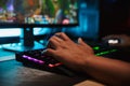 Hands of young gamer man playing video games on computer in dark