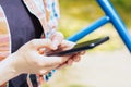 The hands of a young girl holding a cell phone outside. A teenage girl uses a smartphone for online communication on the street. Royalty Free Stock Photo