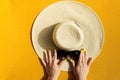 Hands of young girl holding straw hat and sunglasses on vibrant Royalty Free Stock Photo