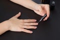 The hands of a young girl make a manicure with shellac