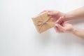 Hands of a young girl opening a gift box on a white background Royalty Free Stock Photo