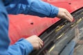 Hands of a young girl with red nails cleaned of autumn leaves wiper blades