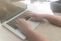 Hands of a young girl typing on a laptop