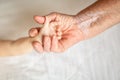 Hands of young great-grandson and old great-grandmother. Happy Family concept. Beautiful conceptual image of Maternity. selective Royalty Free Stock Photo