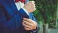 Hands of a young man in a blue suit with a red bow tie Royalty Free Stock Photo