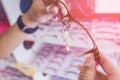 Hands of woman choosing new optical glasses in optician shop. Health care, Royalty Free Stock Photo