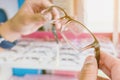 Hands of young man choosing new optical glasses in optician shop. Royalty Free Stock Photo