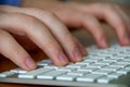 Hands of a young man on a computer keyboard close-up, with depth of field. The concept of learning. doing business and high Royalty Free Stock Photo