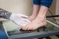 The hands of a young man doctor orthopedist conducts diagnostics, foot foot test of a woman, for the manufacture of Royalty Free Stock Photo