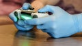 Hands of young man in medical gloves handing remote play station over the table in quarantine period. Stay home safe concept