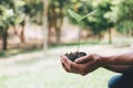 Hands of young man reforesting were planting the seedlings and tree growing into soil while working in the garden as save the