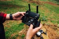 Hands of a young man on a remote control to control a drone on a background of moss in the woods. Using a drone on a hike Royalty Free Stock Photo