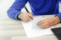 Hands of a young man writing on a piece of paper Royalty Free Stock Photo