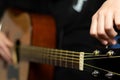 The hands of a young musician playing an acoustic guitar with metal strings close-up with a blurred background Royalty Free Stock Photo