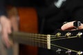 The hands of a young musician playing an acoustic guitar with metal strings close-up with a blurred background Royalty Free Stock Photo