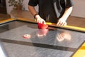 Hands of young people holding striker on air hockey table. Friends playing air hockey. Royalty Free Stock Photo