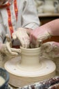 Hands of young potter kneading clay