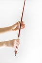 Hands of a young violinist rosin his bow on the background of a piano illuminated by the sun, vertical Royalty Free Stock Photo