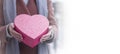 The hands of a young white girl are holding a heart-shaped gift box. Royalty Free Stock Photo