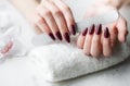 Hands of a young woman with dark red manicure on nails Royalty Free Stock Photo