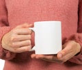 Hands of a young woman holding a Cup of coffee or tea.